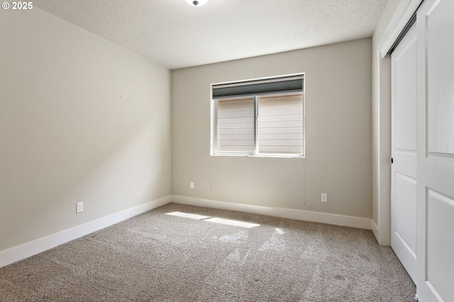521 NE 77th Ave, Hillsboro, OR 97124 - unfurnished bedroom with carpet flooring, a closet, a textured ceiling, and baseboards