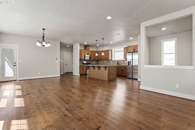 521 NE 77th Ave, Hillsboro, OR 97124 - unfurnished living room featuring baseboards, recessed lighting, a chandelier, dark wood-style flooring, and a textured ceiling