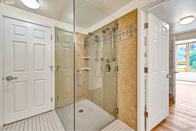 bathroom with walk in shower and tile patterned flooring