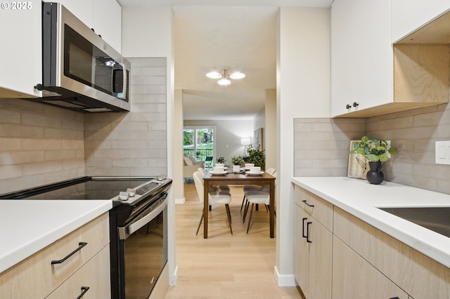 12620 NW Barnes Rd Unit 4, Portland, OR 97229 - kitchen featuring appliances with stainless steel finishes, light brown cabinetry, light wood-style flooring, and decorative backsplash