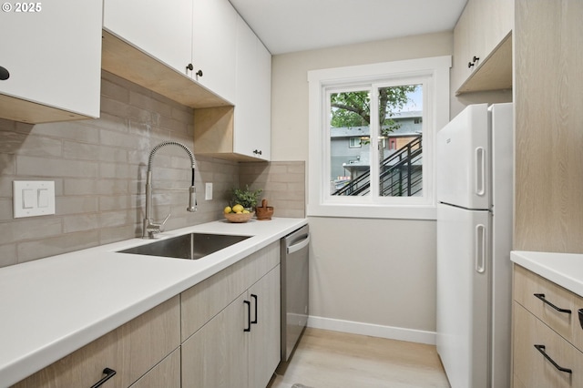 12620 NW Barnes Rd Unit 4, Portland, OR 97229 - kitchen with freestanding refrigerator, stainless steel dishwasher, a sink, decorative backsplash, and light brown cabinets