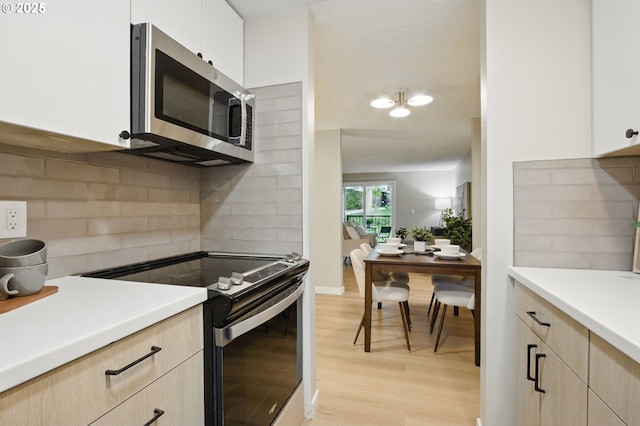 12620 NW Barnes Rd Unit 4, Portland, OR 97229 - kitchen featuring appliances with stainless steel finishes, light brown cabinets, light wood-type flooring, decorative backsplash, and light countertops