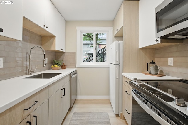 12620 NW Barnes Rd Unit 4, Portland, OR 97229 - kitchen with stainless steel appliances, a sink, light countertops, baseboards, and backsplash