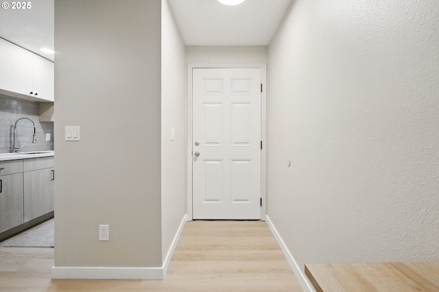 12620 NW Barnes Rd Unit 4, Portland, OR 97229 - hall featuring light wood-style floors, a sink, and baseboards
