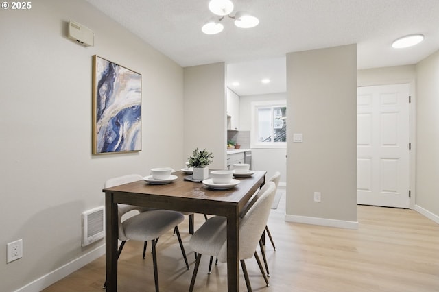 12620 NW Barnes Rd Unit 4, Portland, OR 97229 - dining room featuring light wood finished floors, baseboards, and a chandelier