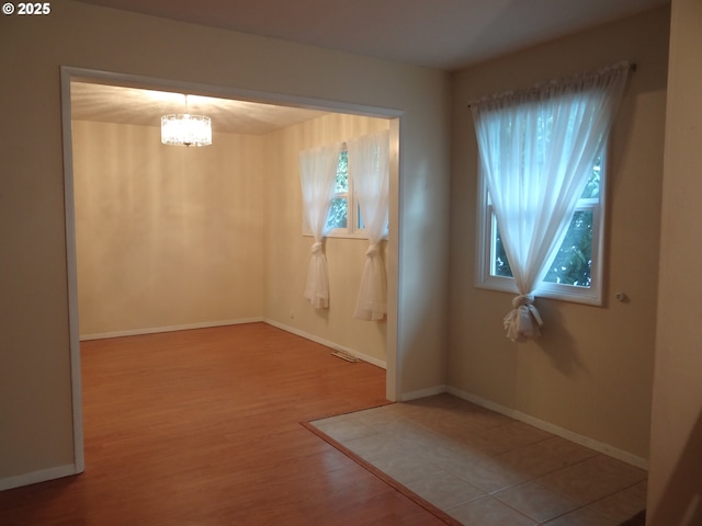 interior space featuring a chandelier, wood-type flooring, and a healthy amount of sunlight