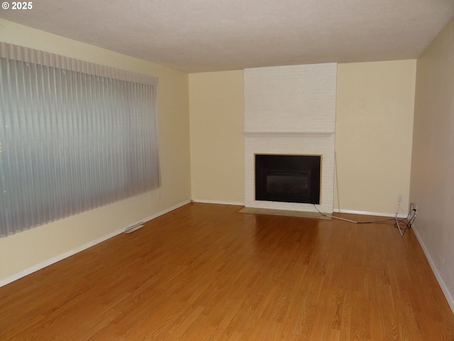 unfurnished living room with a fireplace and hardwood / wood-style flooring