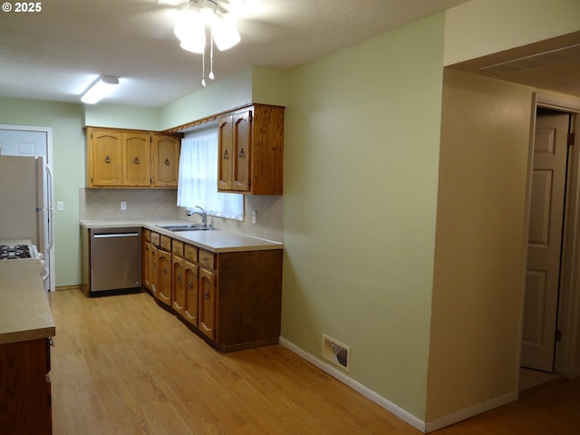 kitchen featuring backsplash, sink, white refrigerator, light hardwood / wood-style flooring, and dishwasher