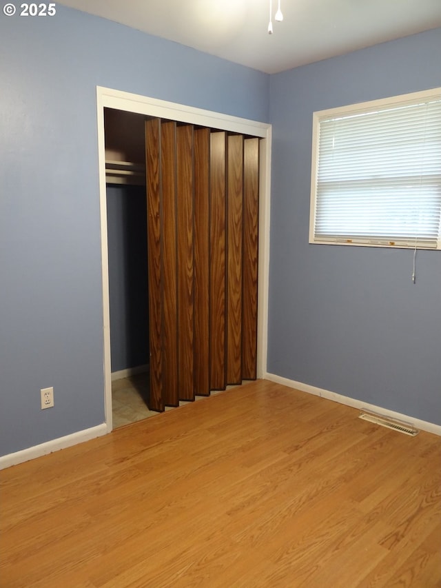 unfurnished bedroom featuring light wood-type flooring and a closet