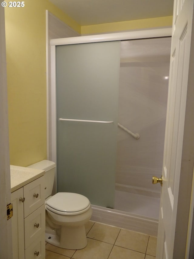 bathroom with tile patterned flooring, vanity, toilet, and an enclosed shower