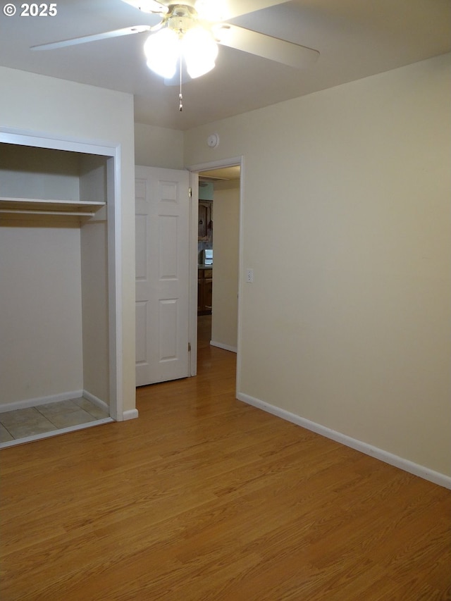 unfurnished bedroom with a closet, light hardwood / wood-style flooring, and ceiling fan