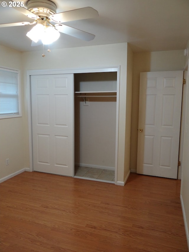 unfurnished bedroom featuring ceiling fan, a closet, and hardwood / wood-style floors