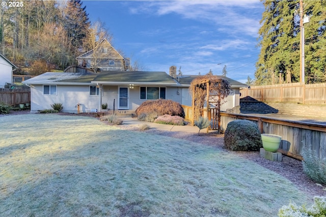 rear view of house featuring a yard