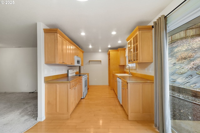 kitchen with sink, white appliances, light wood-type flooring, and light brown cabinets