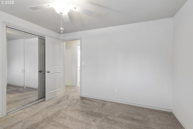 unfurnished bedroom with light colored carpet, a textured ceiling, ceiling fan, and a closet