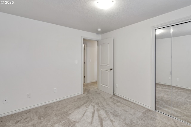 unfurnished bedroom with light colored carpet, a textured ceiling, and a closet