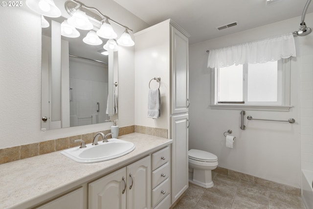 bathroom featuring tile patterned flooring, vanity, toilet, and walk in shower