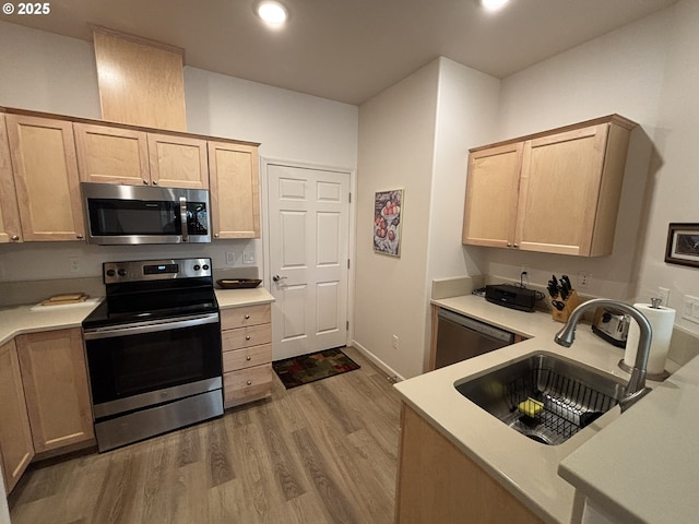 1690 32nd St, Florence, OR 97439 - kitchen with appliances with stainless steel finishes, wood finished floors, light countertops, light brown cabinets, and recessed lighting