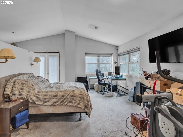 carpeted bedroom with french doors and lofted ceiling