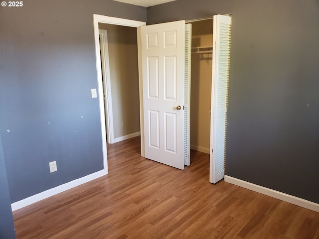 unfurnished bedroom featuring light hardwood / wood-style floors and a closet