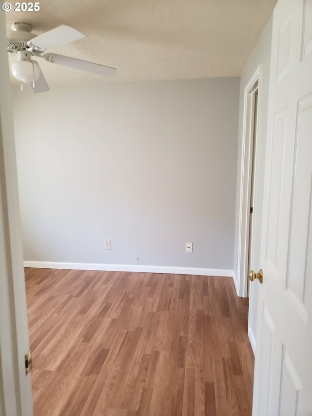 spare room featuring ceiling fan, wood-type flooring, and a textured ceiling