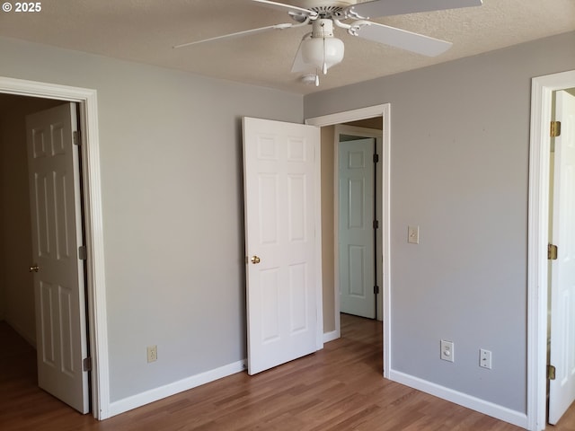 unfurnished bedroom with ceiling fan and light wood-type flooring