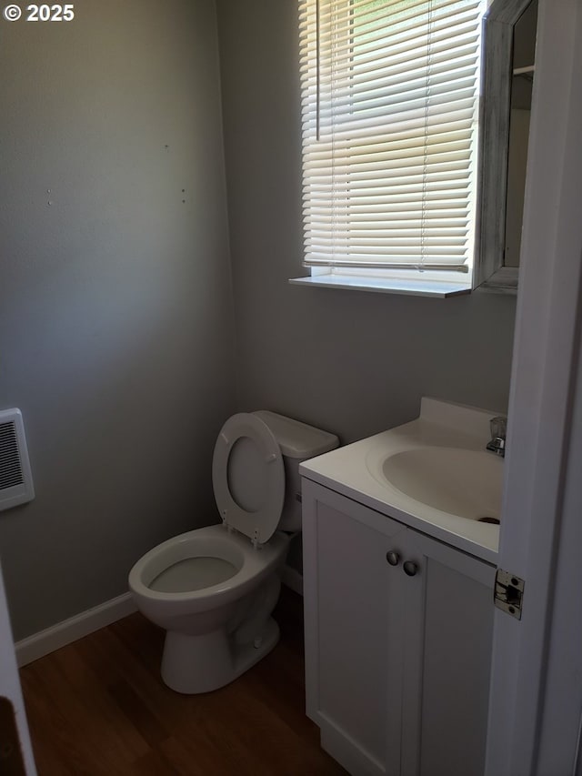 bathroom with hardwood / wood-style floors, vanity, and toilet