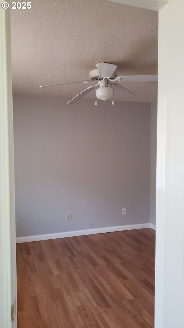 spare room featuring hardwood / wood-style floors and a textured ceiling