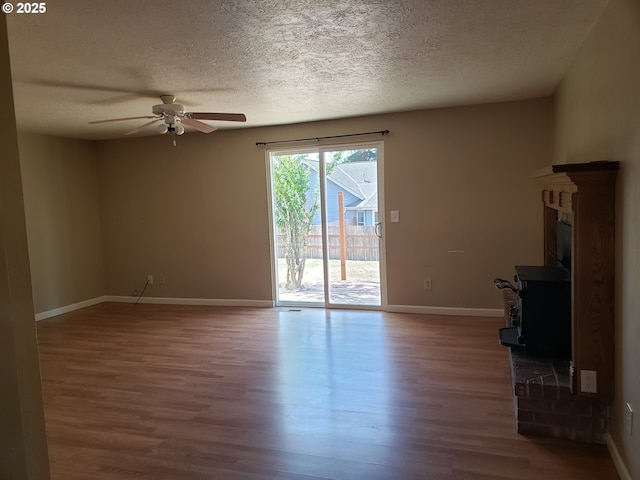 unfurnished living room with ceiling fan, wood-type flooring, and a textured ceiling