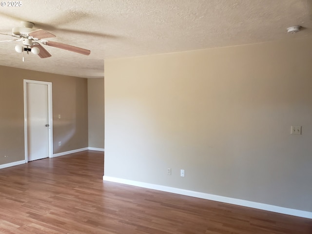 spare room with ceiling fan, a textured ceiling, and hardwood / wood-style flooring