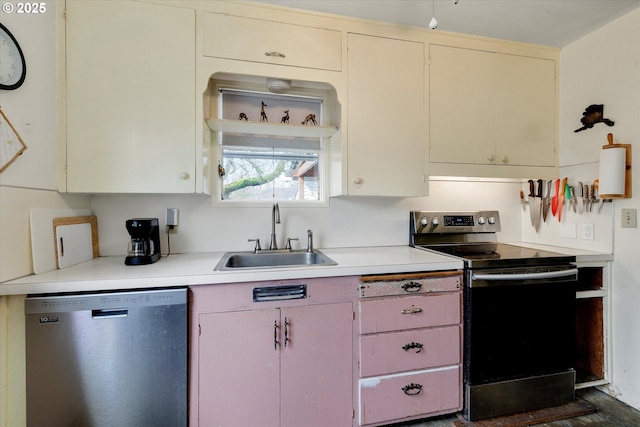 kitchen with appliances with stainless steel finishes, light countertops, and a sink