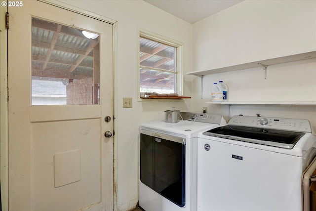 clothes washing area featuring laundry area, washing machine and dryer, and a healthy amount of sunlight