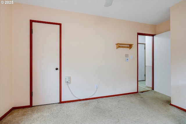 empty room featuring baseboards, carpet floors, and ceiling fan