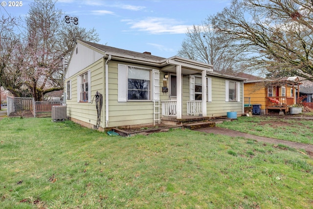 view of front of house with a front lawn, central AC, and fence