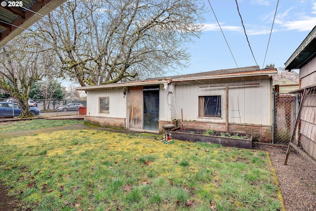 rear view of house with a yard and fence