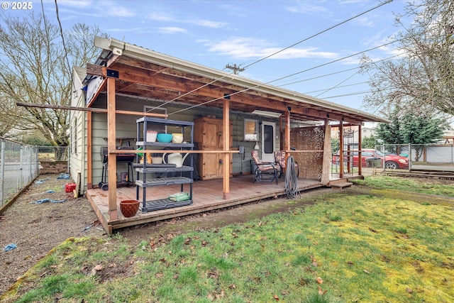 rear view of house with a yard and fence