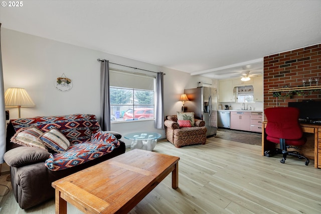 living area with light wood finished floors and a ceiling fan