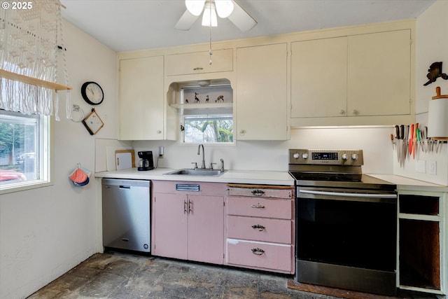 kitchen with a ceiling fan, a sink, light countertops, cream cabinetry, and appliances with stainless steel finishes