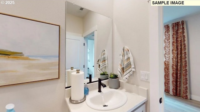 bathroom with hardwood / wood-style flooring and vanity