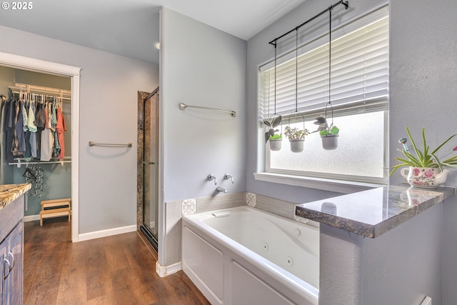 222 Twin Springs Ln, Roseburg, OR 97470 - bathroom featuring wood finished floors, a stall shower, a whirlpool tub, a walk in closet, and vanity