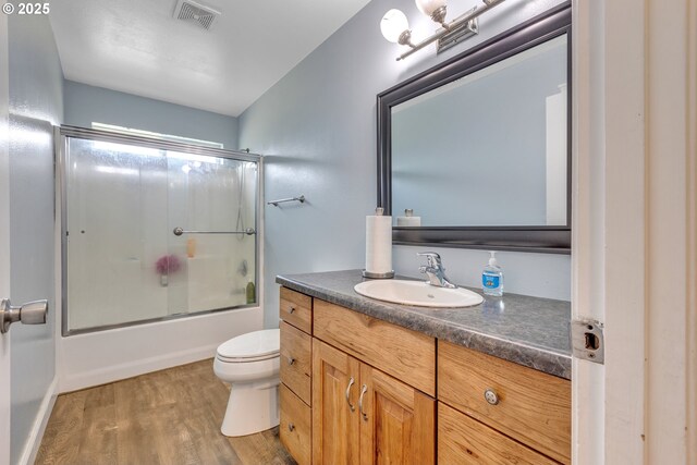 222 Twin Springs Ln, Roseburg, OR 97470 - bathroom with toilet, vanity, wood finished floors, and enclosed tub / shower combo