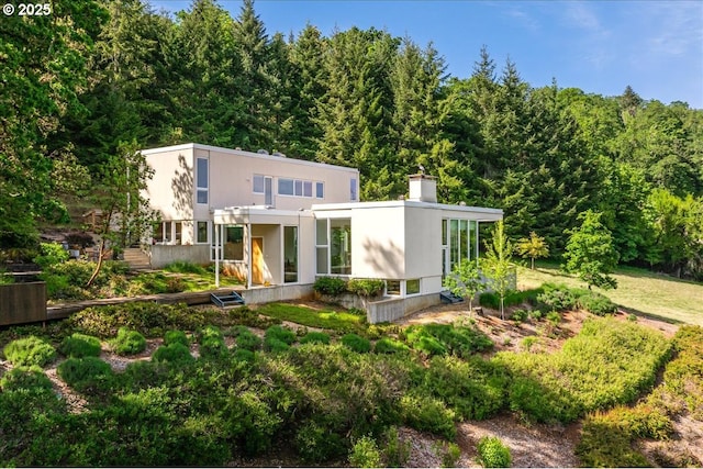 13440 SW Mccabe Chapel Rd, Mcminnville, OR 97128 - view of front of home featuring a chimney, stucco siding, and a forest view