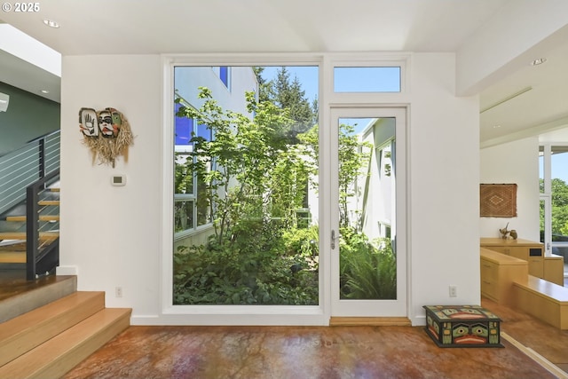 doorway featuring stairs and finished concrete flooring