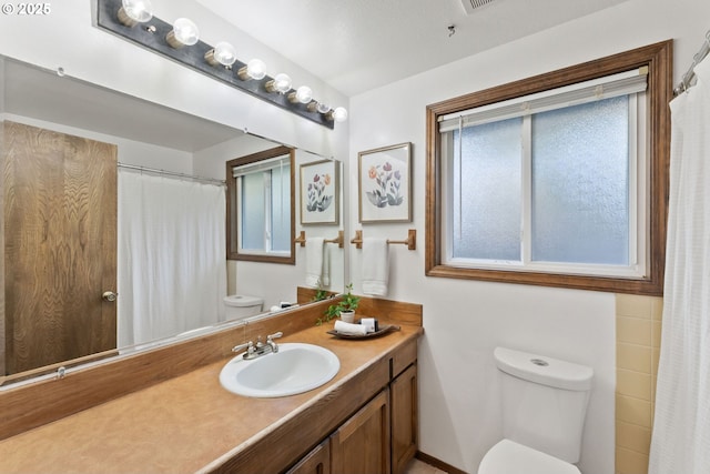 full bath with a shower with curtain, toilet, and vanity