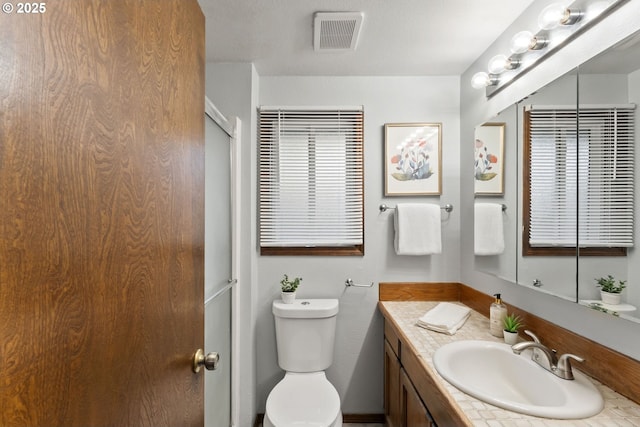 bathroom with visible vents, toilet, and vanity