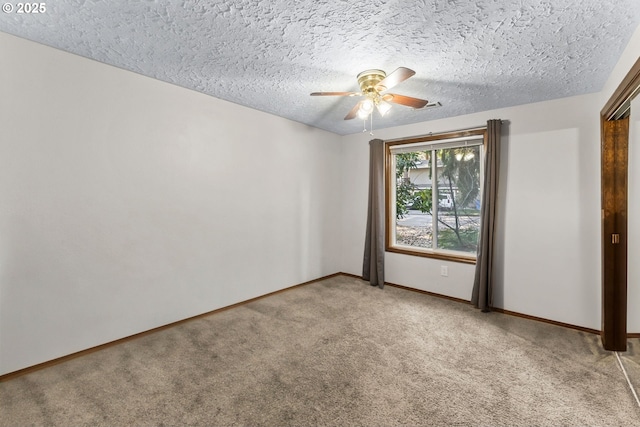 spare room with baseboards, carpet floors, a textured ceiling, and ceiling fan