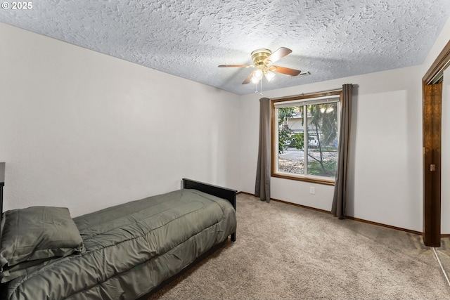 bedroom with light carpet, ceiling fan, a textured ceiling, and baseboards