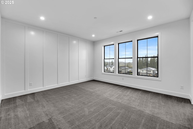 empty room featuring dark colored carpet, recessed lighting, visible vents, and baseboards