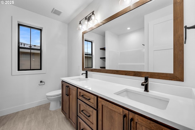 full bathroom with toilet, visible vents, a sink, and baseboards