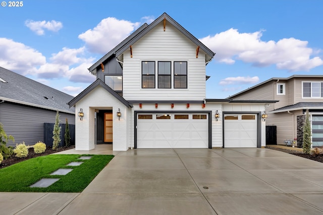 view of front of home featuring an attached garage, board and batten siding, concrete driveway, and brick siding